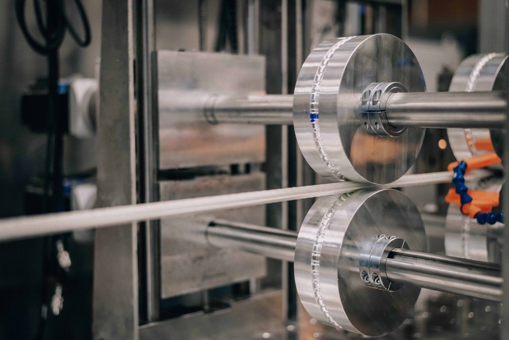 thermoplastic rebar on two rollers in the CFM, molding the corrugations onto the rebar.